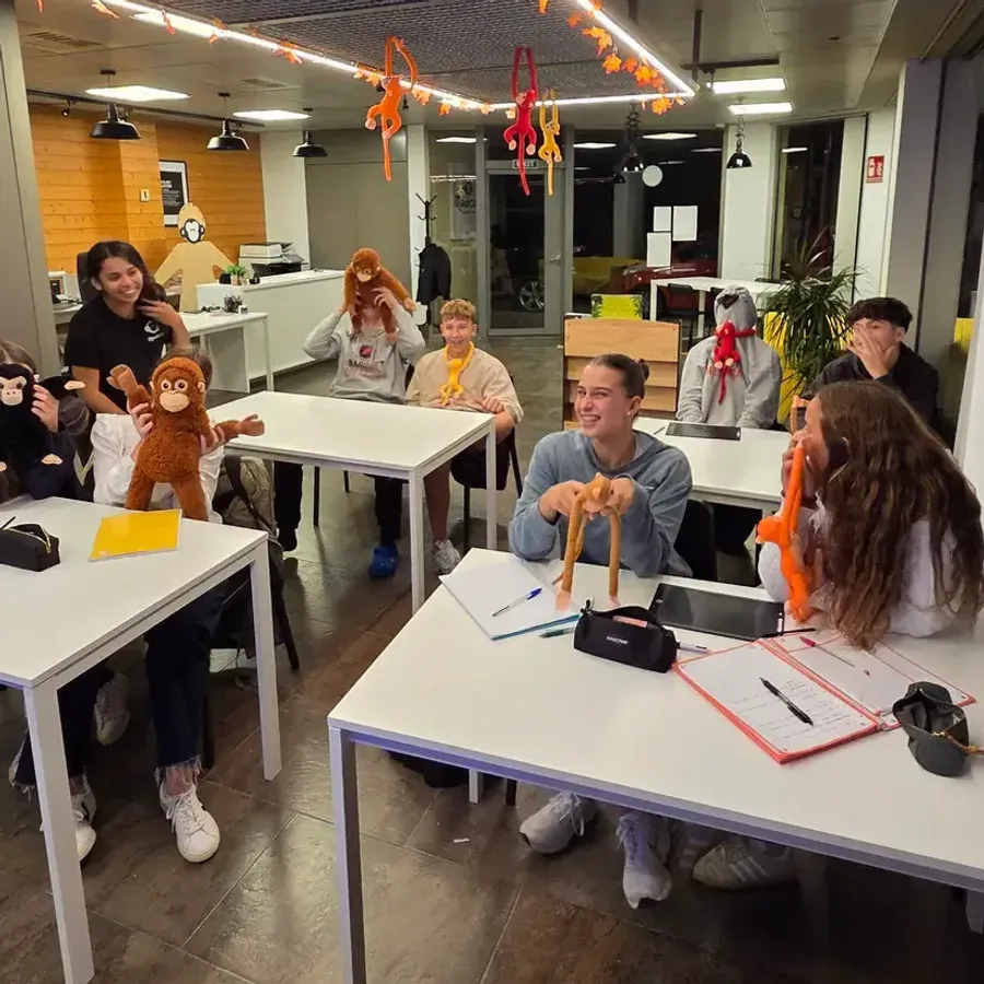 Alumnes de secundària amb peluixos de mico a l'aula decorada de tardor